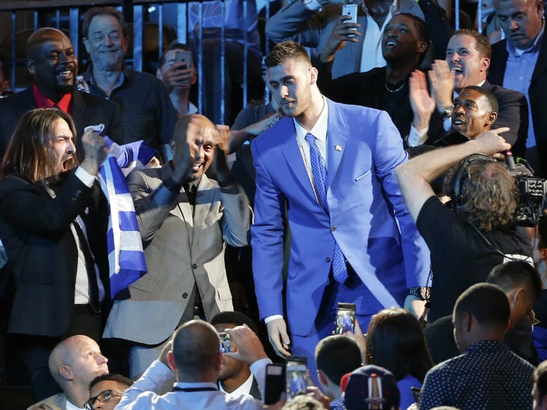 Georgios Papagiannis, center, stands as he is announced as the 13th overall pick by the Phoenix Suns during the NBA basketball draft, Thursday, June 23, 2016, in New York. 